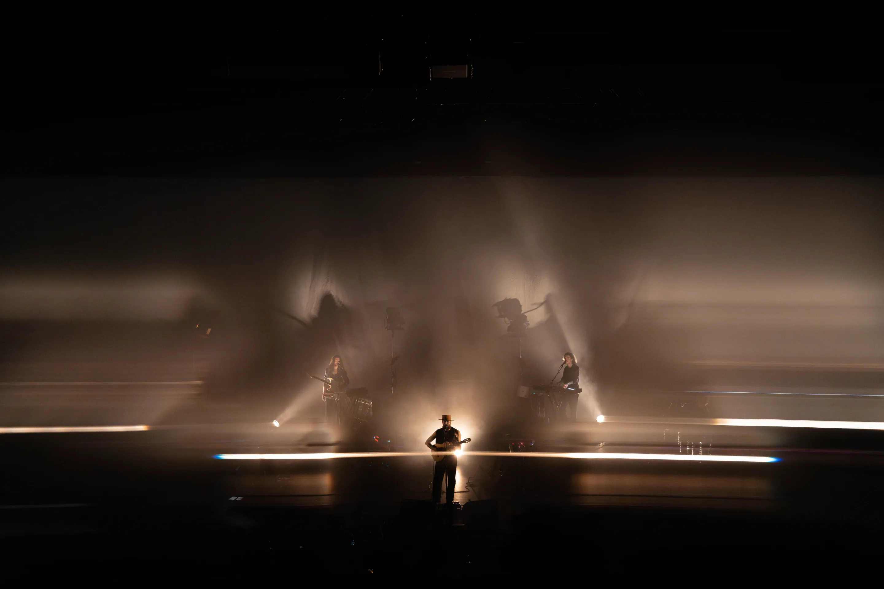 ry x, live performance, indie pop electronica artist, playing guitar with immersive lighting and visuals with audience interaction at a concert.