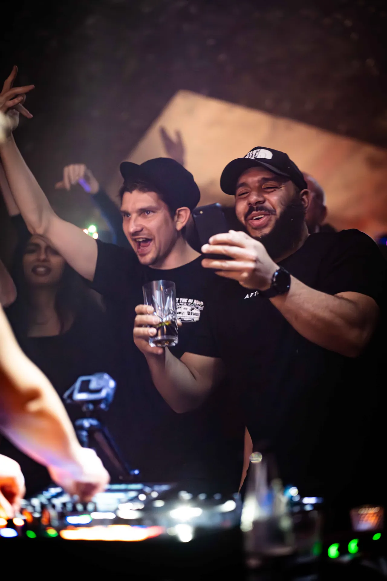 people, dancing, cheering to a dj in a party scene